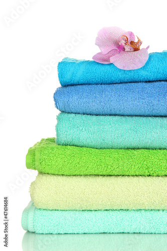 Photo: Stack of towels with fragrant flower isolated on white Stack of towels with fragrant flower isolated on white
