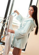 Photo: Beautiful woman hanging freshly washed clothes on the rack Beautiful woman hanging freshly washed clothes on the rack