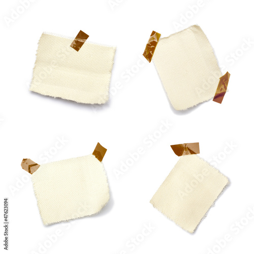 Photo: Petits morceaux de toile sur fond blanc tenu par de l'adhésif Petits morceaux de toile sur fond blanc tenu par de l'adhésif