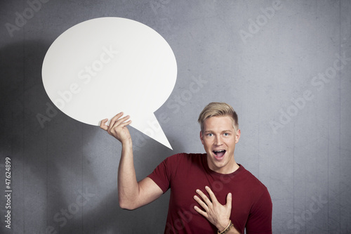 Photo: Joyful man holding empty speech bubble. Joyful man holding empty speech bubble.