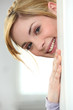 Foto: Blonde woman peeking behind the wall Blonde woman peeking behind the wall
