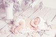 Newborn baby sleeping on leaves over white wooden background. Fi