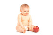 Photo: Baby boy sitting and looking at an apple Baby boy sitting and looking at an apple