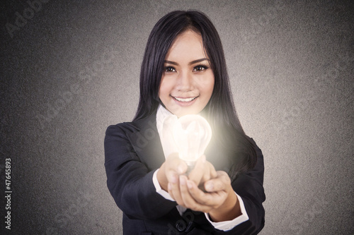 Photo: Businesswoman give lit lightbulb Businesswoman give lit lightbulb