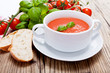 Frische tomatensuppe in einer weißen suppentasse mit basilikum