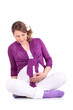Pregnant woman sits on floor and holds her belly isolated