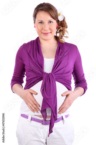 Photo: Happy pregnant woman with flower in hair holds belly and looks Happy pregnant woman with flower in hair holds belly and looks