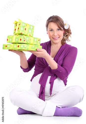 Photo: Happy pregnant woman sits on floor and holds green boxes Happy pregnant woman sits on floor and holds green boxes