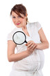 Pregnant woman in white with magnifying glass looks at camera