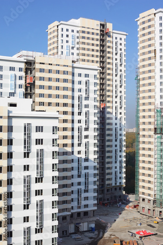 Photo: Parts of high-rise buildings under construction at sunny day. Parts of high-rise buildings under construction at sunny day.