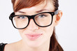 Beautiful woman in big black glasses smiles and looks at camera.