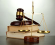 Golden scales of justice, gavel and books on grey background