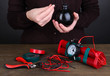 Human makes timebomb on wooden table on black background