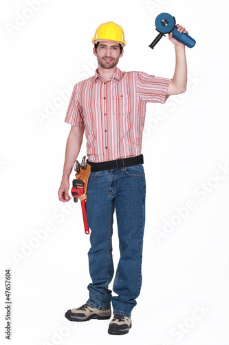 Photo: A handyman holding a grinding machine. A handyman holding a grinding machine.