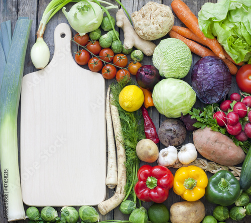 Photo: Vegetables and spices vintage border and empty cutting board Vegetables and spices vintage border and empty cutting board