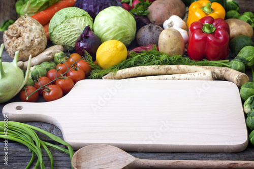 Photo: Vegetables and spices vintage border and empty cutting board Vegetables and spices vintage border and empty cutting board