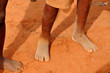 dirty and bare child's feet on gravel. Poverty concept
