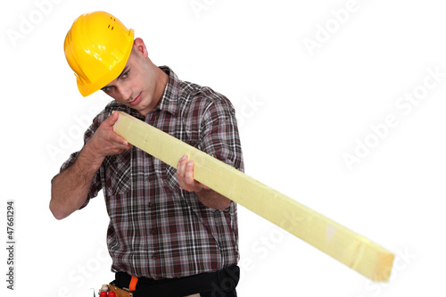 Photo: Man holding wooden beam Man holding wooden beam