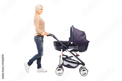 Photo: Full length portrait of a mother pushing a baby stroller Full length portrait of a mother pushing a baby stroller