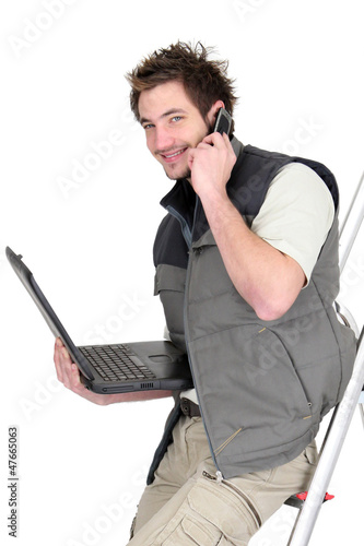 Photo: Tiler with a phone and laptop Tiler with a phone and laptop