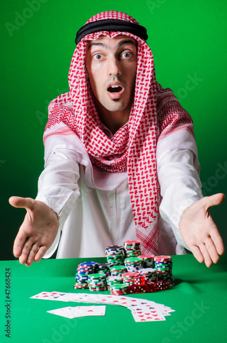 Photo: Arab playing in casino - gambling concept with man Arab playing in casino - gambling concept with man
