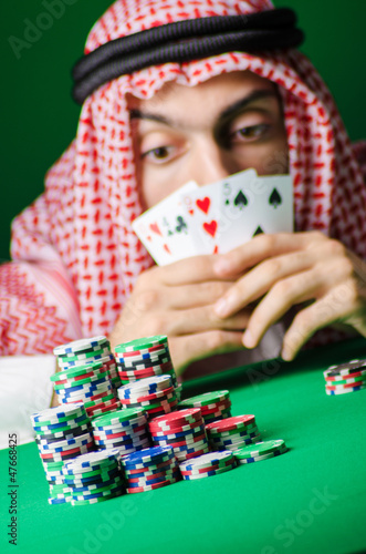 Photo: Arab playing in casino - gambling concept with man Arab playing in casino - gambling concept with man
