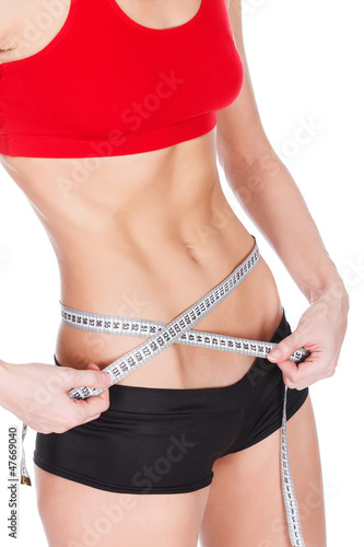 Photo: Woman measuring waist with a tape measure, isolated on white Woman measuring waist with a tape measure, isolated on white