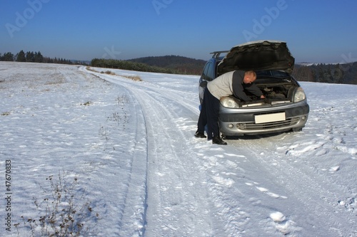 Photo: man repairing the car on a deserted road, winter weather man repairing the car on a deserted road, winter weather