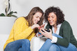 Two Beautiful Women with Mobile Phone in the Living Room