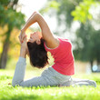 Pretty woman doing yoga exercises in the park