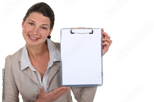 Photo: Brunette presenting blank clip-board Brunette presenting blank clip-board