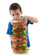 Photo: Cute child making big sandwich isolated on white Cute child making big sandwich isolated on white