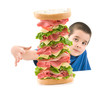 Photo: Cute boy enjoying big sandwich isolated on white Cute boy enjoying big sandwich isolated on white