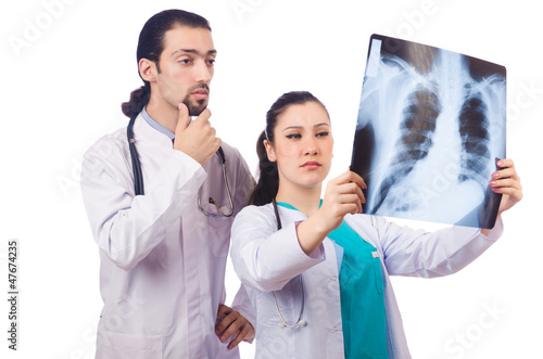 Photo: Two doctors looking at x-ray image on white Two doctors looking at x-ray image on white