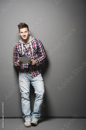 Photo: Smiling young urban man with a tablet Smiling young urban man with a tablet