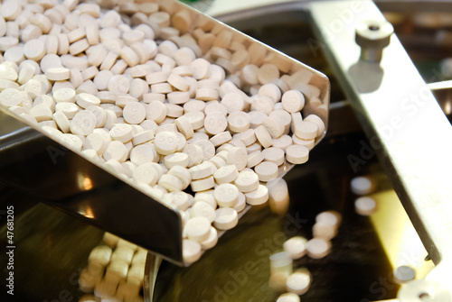 Photo: Closeup of pharmaceutical medicine tablet pill production in the Closeup of pharmaceutical medicine tablet pill production in the