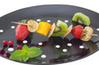 Photo: Mini blini (pancake) with cut fruits on skewers, on black plate. Mini blini (pancake) with cut fruits on skewers, on black plate.