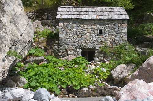 stone watermill with shingle roof along Shala river in Theth Valley, Albania 