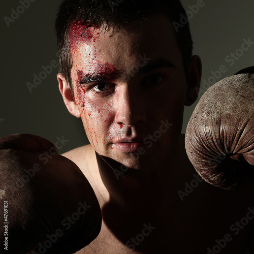 Photo: Man in boxing gloves with blood on a face Man in boxing gloves with blood on a face