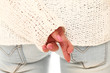 Close up of crossed fingers behind of women back