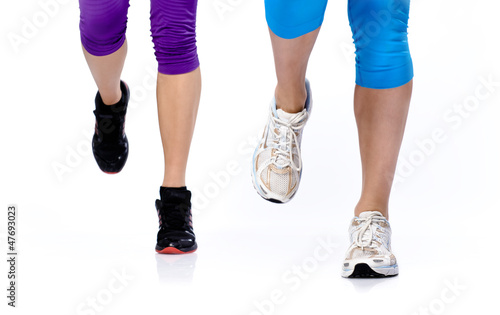 Photo: Close-up photo of two woman's legs running on a white background Close-up photo of two woman's legs running on a white background
