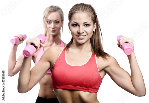 Photo: Two attractive athletic girl with dumbbells Two attractive athletic girl with dumbbells