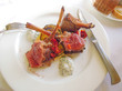 Photo: Lamb chops served on a bed of vegetables on a white plate Lamb chops served on a bed of vegetables on a white plate