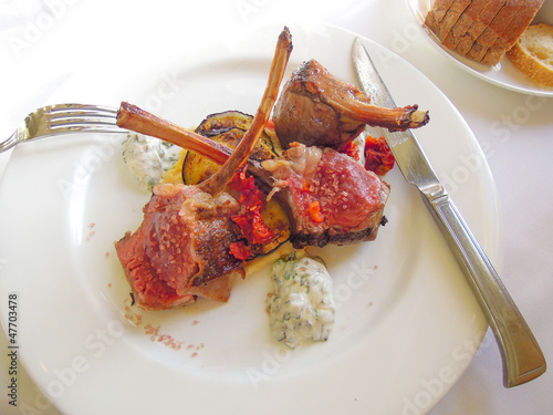 Photo: Lamb chops served on a bed of vegetables on a white plate Lamb chops served on a bed of vegetables on a white plate
