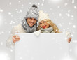 couple in a winter clothes holding blank board