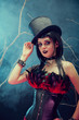 Attractive smiling gothic girl in tophat and feather corset