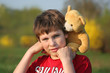 Junge mit Teddy im Grünen