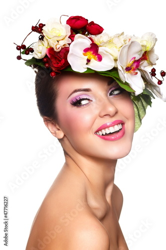 Photo: beautiful woman with bright makeup with colorful flowers on head beautiful woman with bright makeup with colorful flowers on head