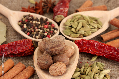 Photo: Nutmeg and other spices on sackcloth background Nutmeg and other spices on sackcloth background