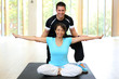Personal trainer instructing woman in gymnastics